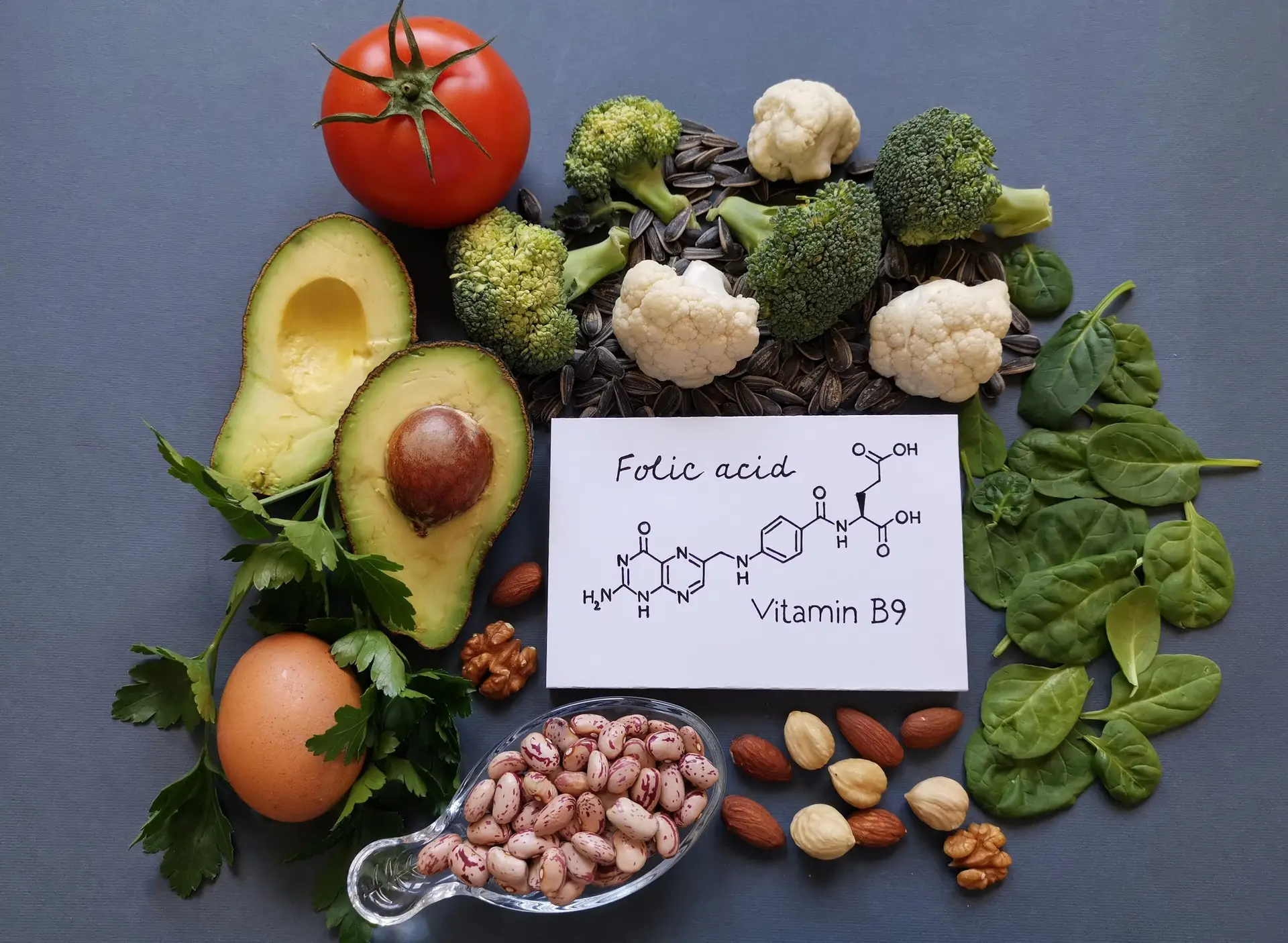 Illustratie van voedingsbronnen rijk aan natuurlijk folaat (zoals spinazie, kikkererwten en avocado)