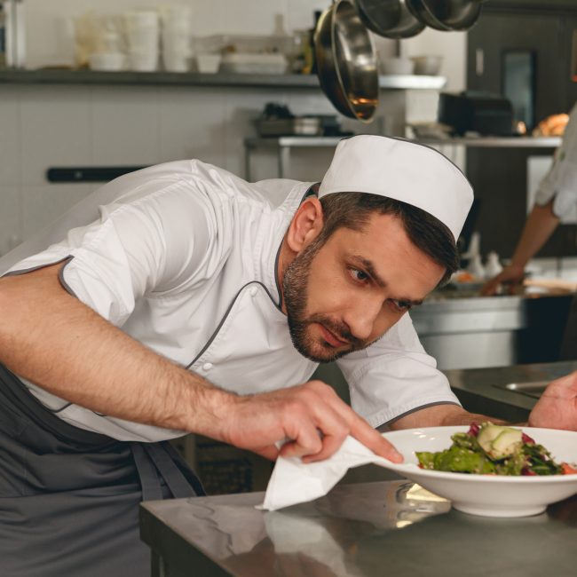 Chef bereidt salade in de moderne keuken van een restaurant.