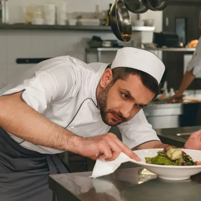 Chef bereidt salade in de moderne keuken van een restaurant.