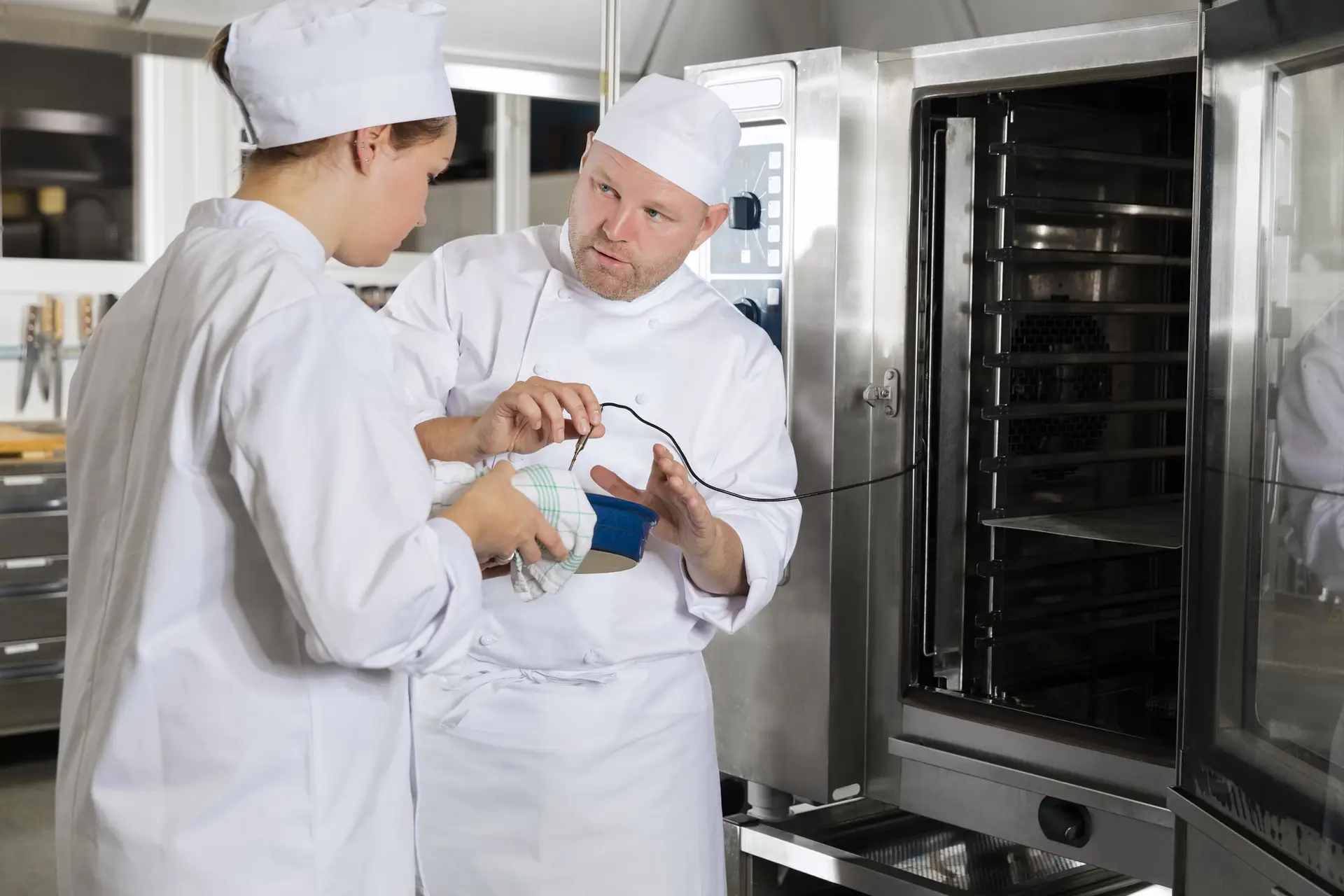 Chef-kok helpt studenten met koken in een grote keuken