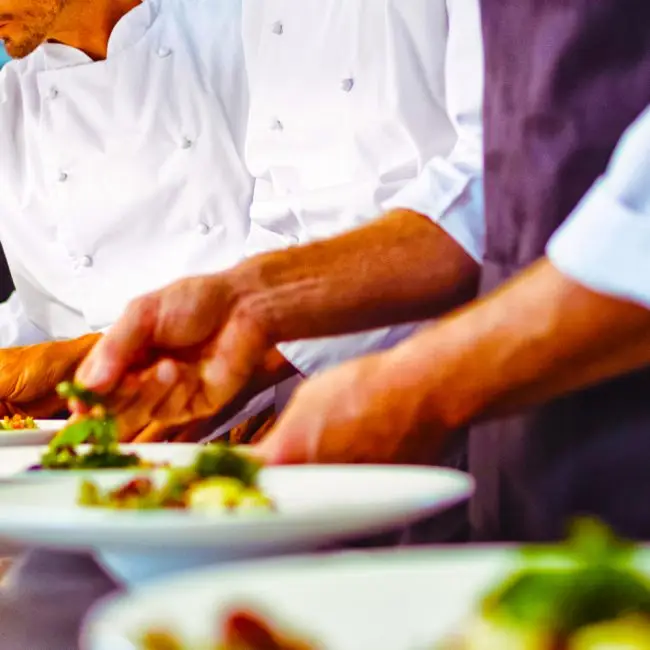 Een professioneel keukenteam dat samenwerkt aan een werktafel