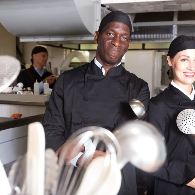 Twee lachende chefs in een professionele keuken