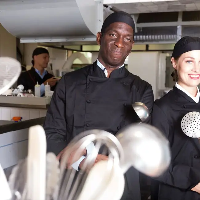 Twee lachende chefs in een professionele keuken