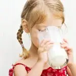 Kind drinkt een glas melk. Melk en the china study