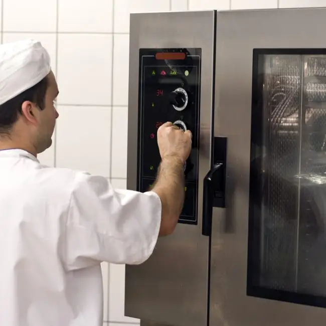 Cook at commercial stove. A professional stove (oven)