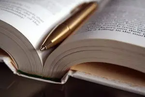 Open boek met gouden pen – symbool voor kennis en ervaring binnen Natuurlijke Gezondheid.