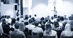 Publiek luistert aandachtig naar een lezing over voeding en gezondheid in een professionele setting.