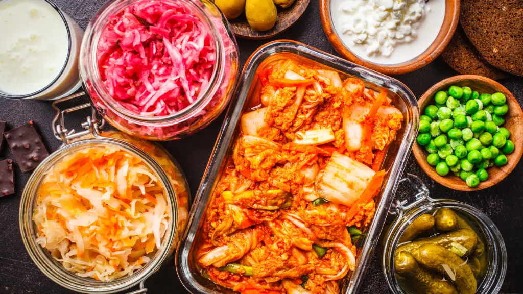 Gefermenteerde groenten zoals kimchi, zuurkool en rode kool in glazen potten
