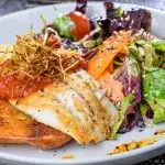 Bord met vis, groenten en zaden als voorbeeld van samenhang tussen plantaardige en dierlijke voeding